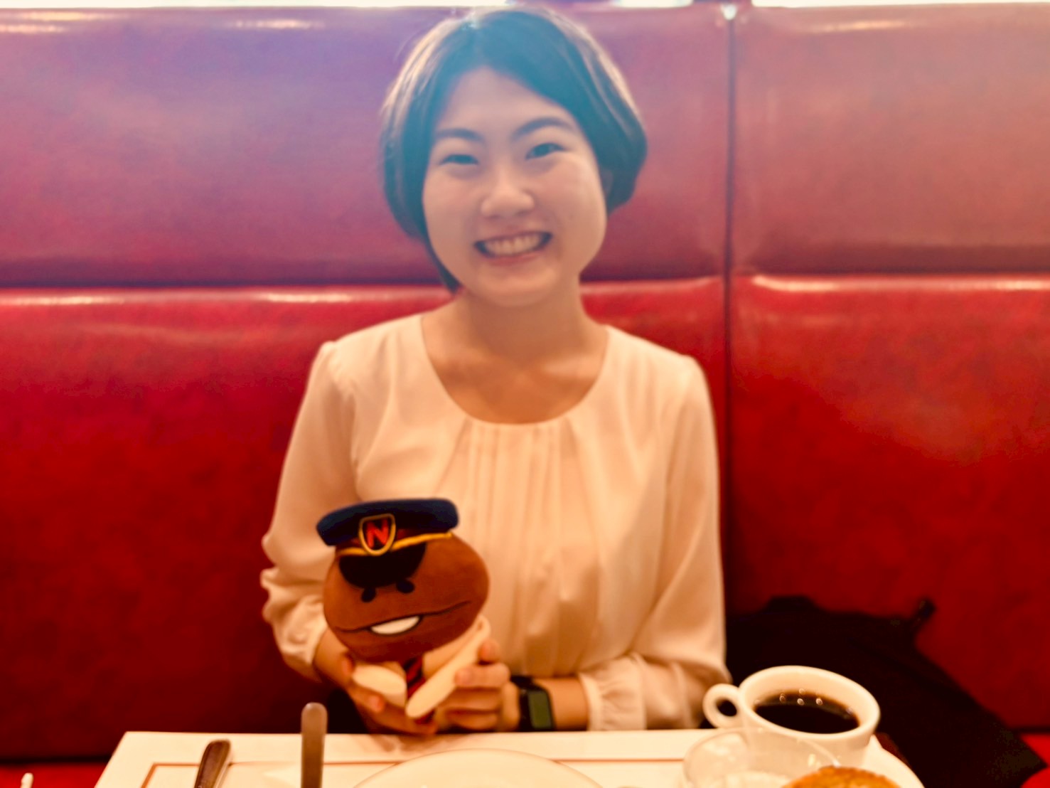 徳永先生がなめこ駅長のぬいぐるみを抱いている写真