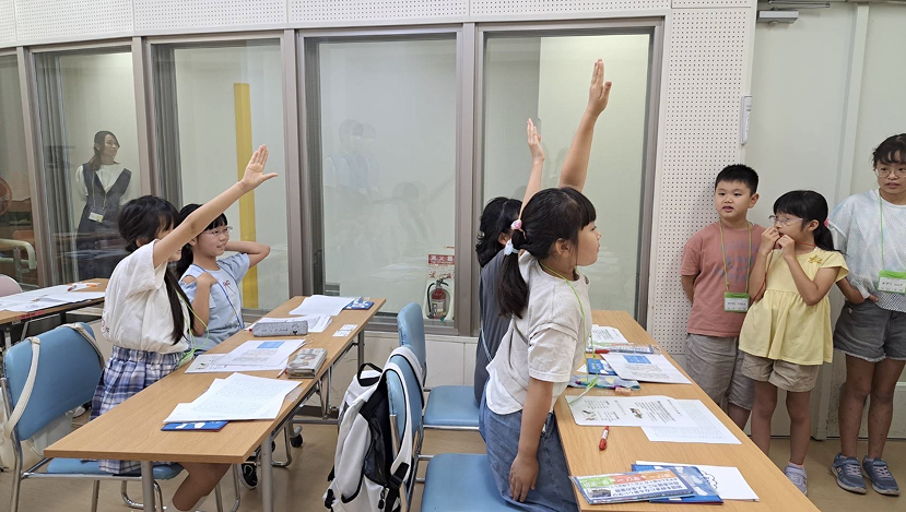 子どもたちがワークショップで手を挙げている様子