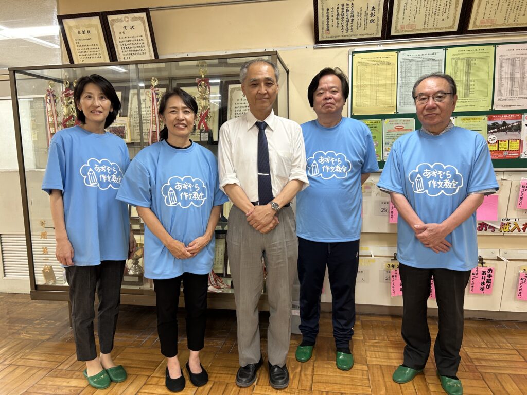 足立区立舎人小学校　土屋校長とあおぞら作文教室の講師たち。校舎内にて